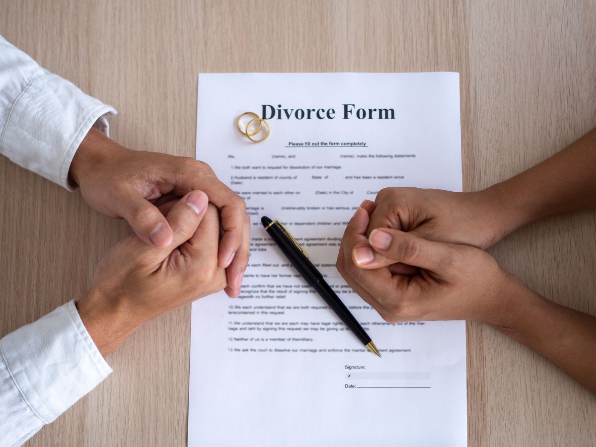 Divorce Form with wedding rings and a pen on it